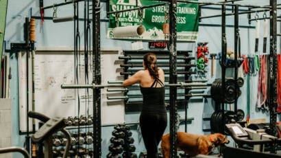 Woman standing at the squat rack at the gym summit strength and fitness