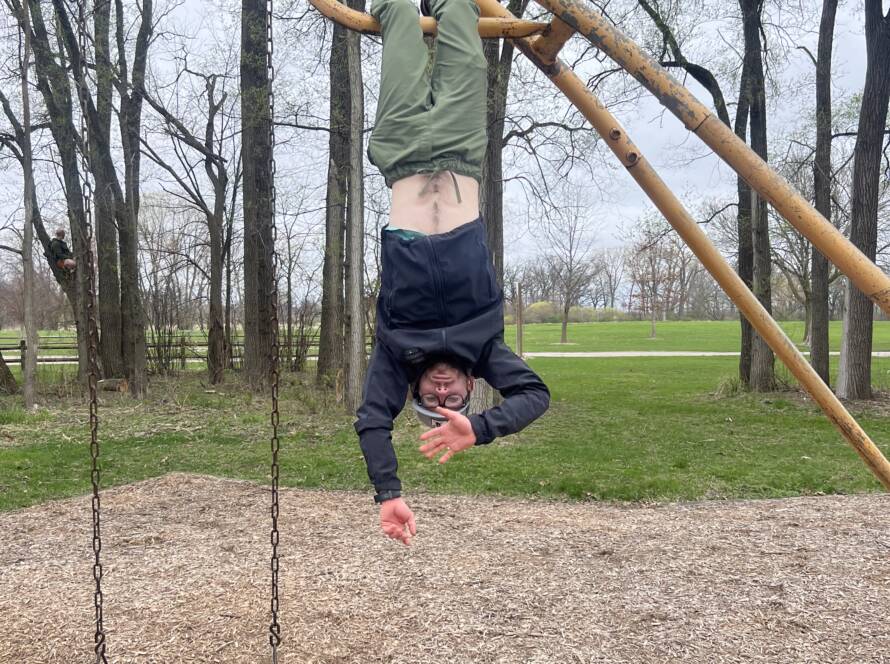 Patrick Hanging upside down doing calisthenics at the playground