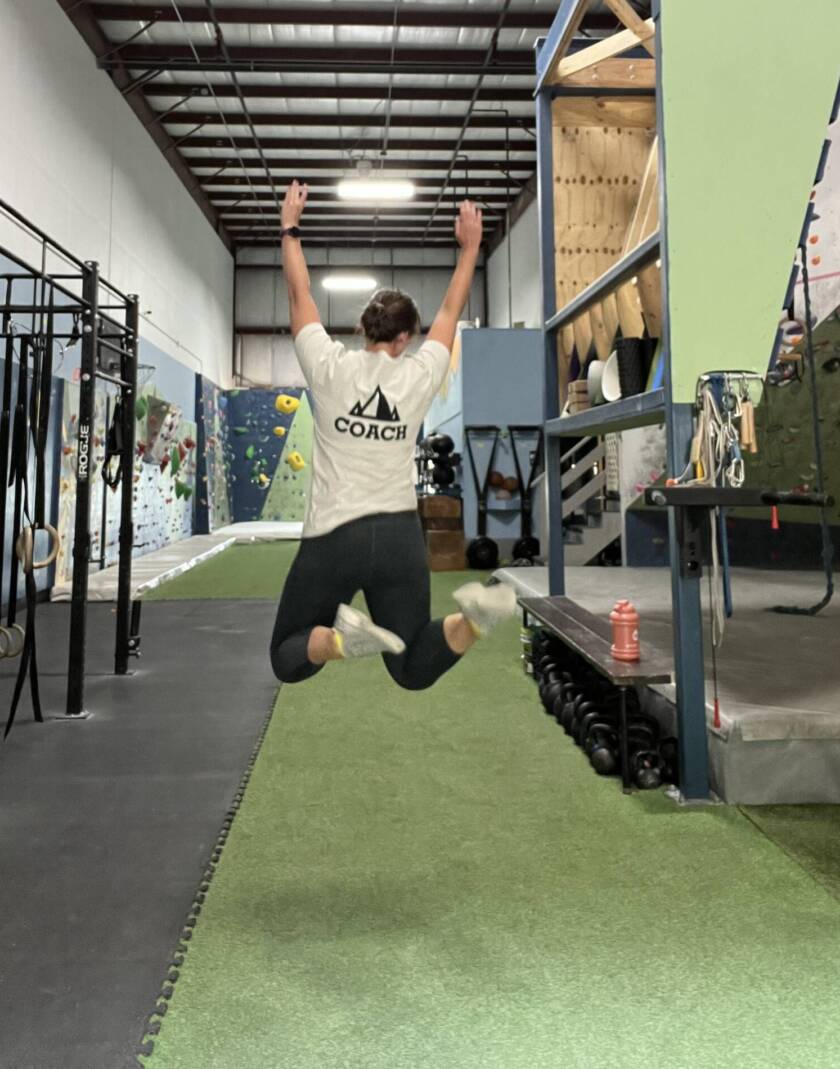 Coach Courtney jumping at summit