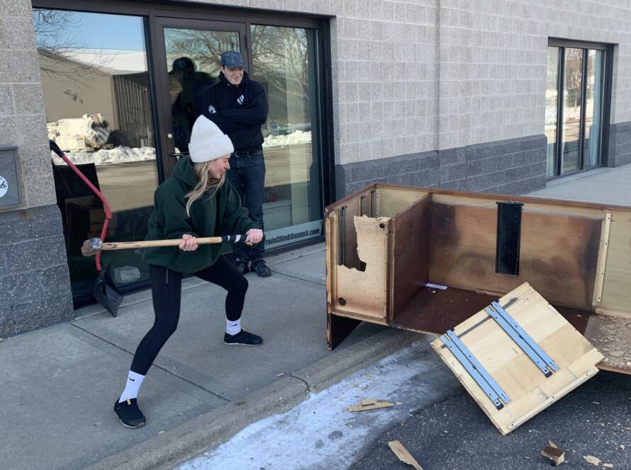 Tess Kachiroubas working out by smashing a desk with a sledgehammer