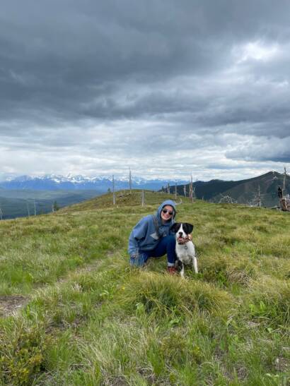 Tess sitting in a field with her dog