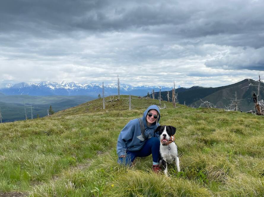 Tess sitting in a field with her dog