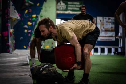 Patrick lifting large sandbag off the ground