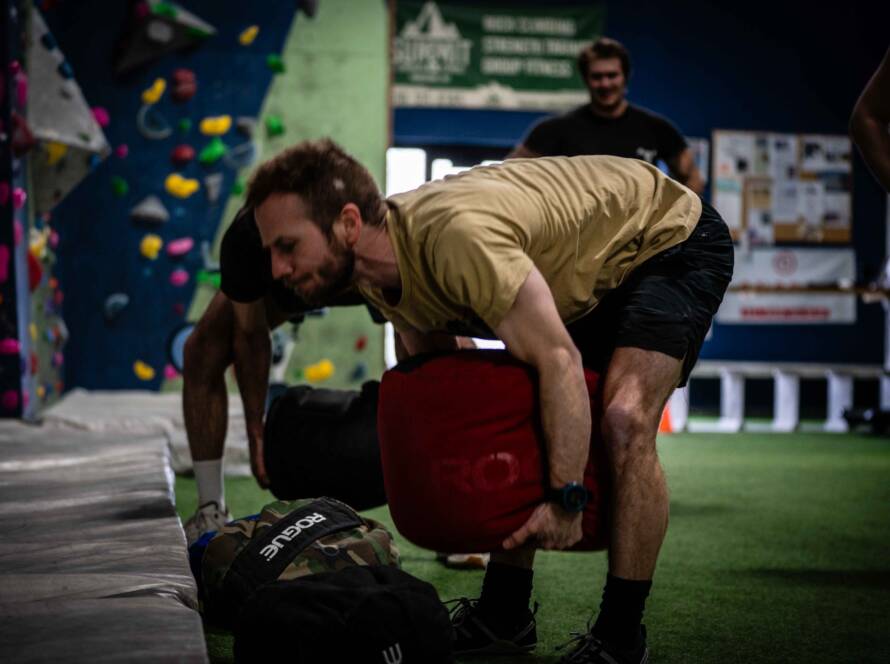 Patrick lifting large sandbag off the ground