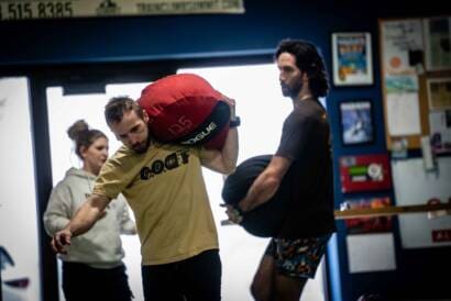 Patrick and coach kubi carrying sandbags and building strength using the mindset of a professional