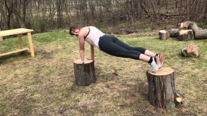 Courtney Weber practicing balance training by planking in the outdoors.