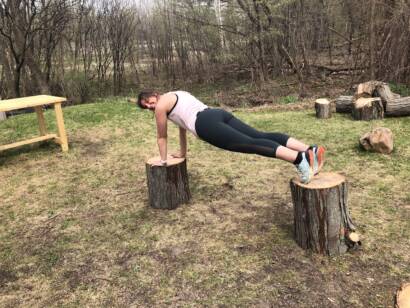 Courtney Weber practicing balance training by planking in the outdoors.
