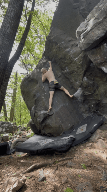 Eamon climbing a boulder outside at devils lake state park