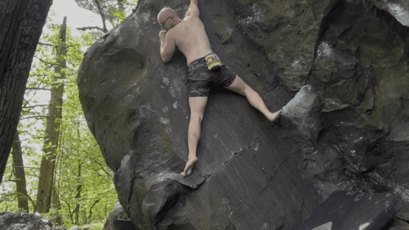 Eamon climbing a boulder outside at devils lake state park