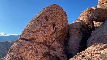 Megan topping a ropes route on outdoor climbing day trip in Red Rocks