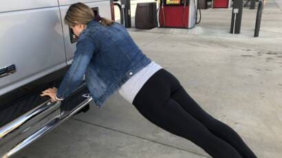 Courtney is doing push ups on the bumper of a van