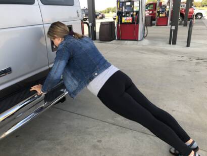 Courtney is doing push ups on the bumper of a van
