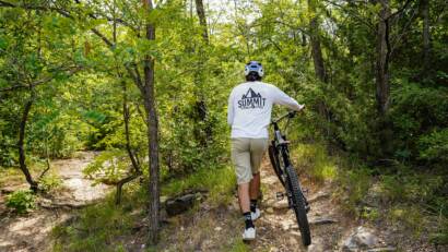coach kubi walking his bike up the trails at quary ridge in madison wisconsin