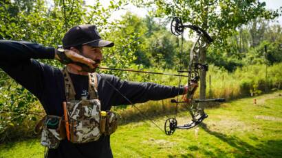 coach kubi practicing with his bow in his back yard