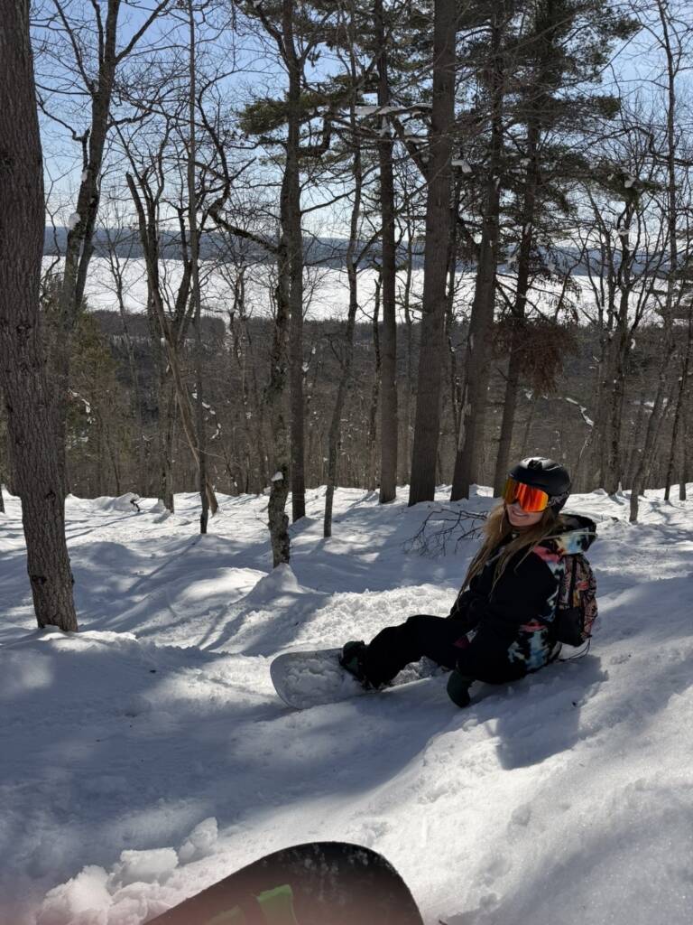 outdoors and mental health improvement with Erica sitting on a slope during a snowboarding session
