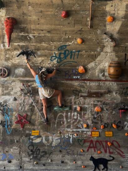 Erica using her training for real life strength to scale a wall in Spain
