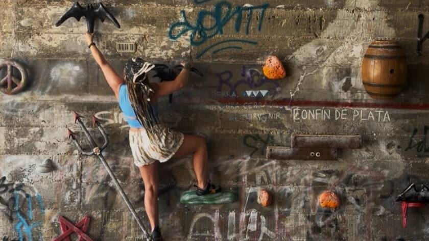 Erica using her training for real life strength to scale a wall in Spain
