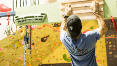 Photo of Coach Patrick using a hangboard for climbing training.