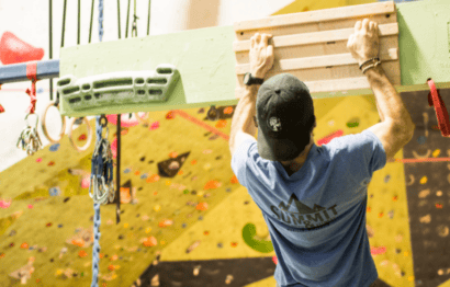 Photo of Coach Patrick using a hangboard for climbing training.